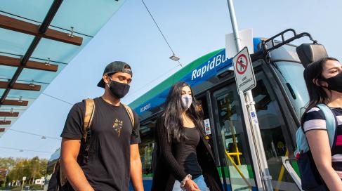 Students walking by translink bus